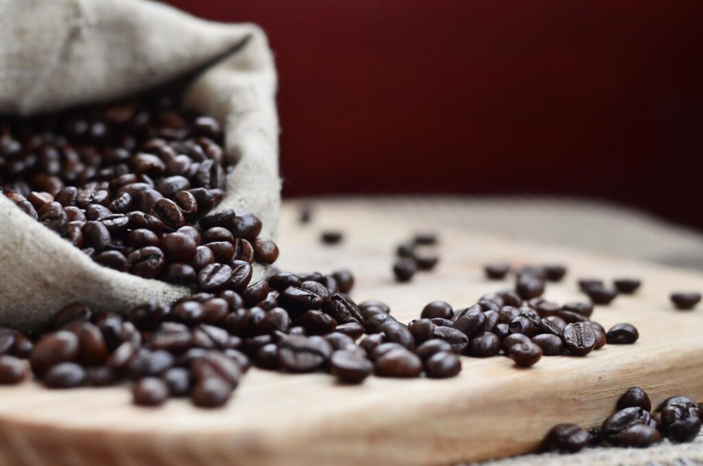 a-full-bag-of-brown-coffee-beans-lies-on-a-wooden-2024-07-24-14-37-14-utc