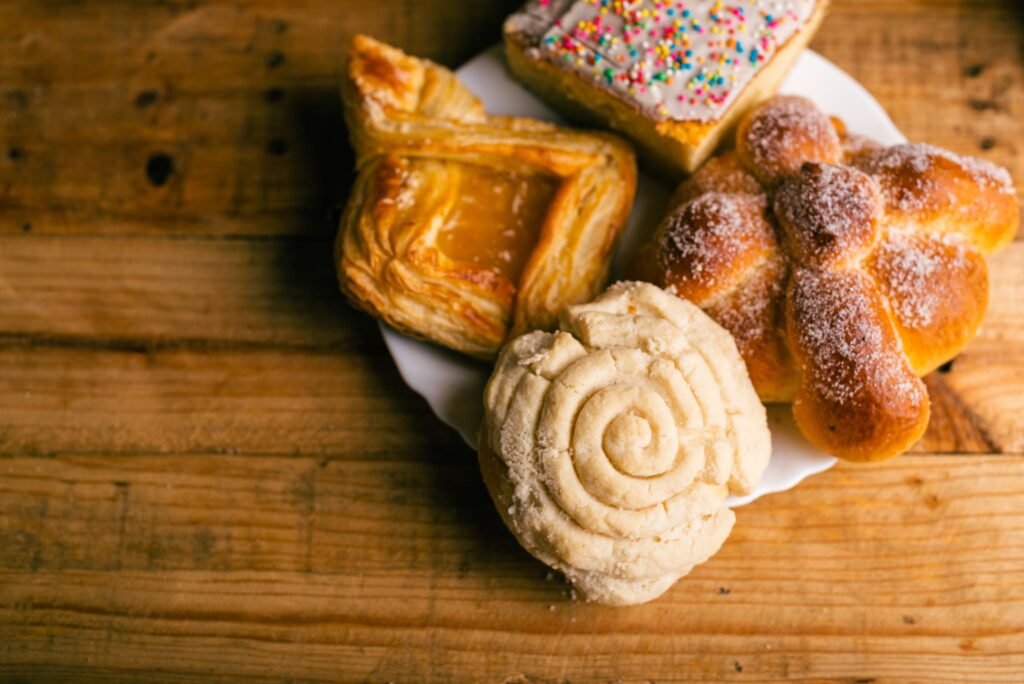 concha-and-other-sweet-breads-on-wooden-table-typ-2023-11-27-05-13-31-utc