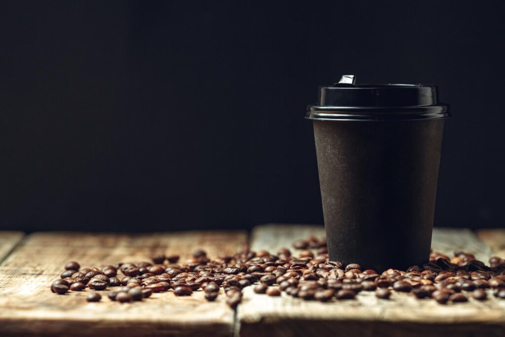 take-away-coffee-cup-and-coffee-beans-on-wooden-ba-2023-11-27-04-51-08-utc